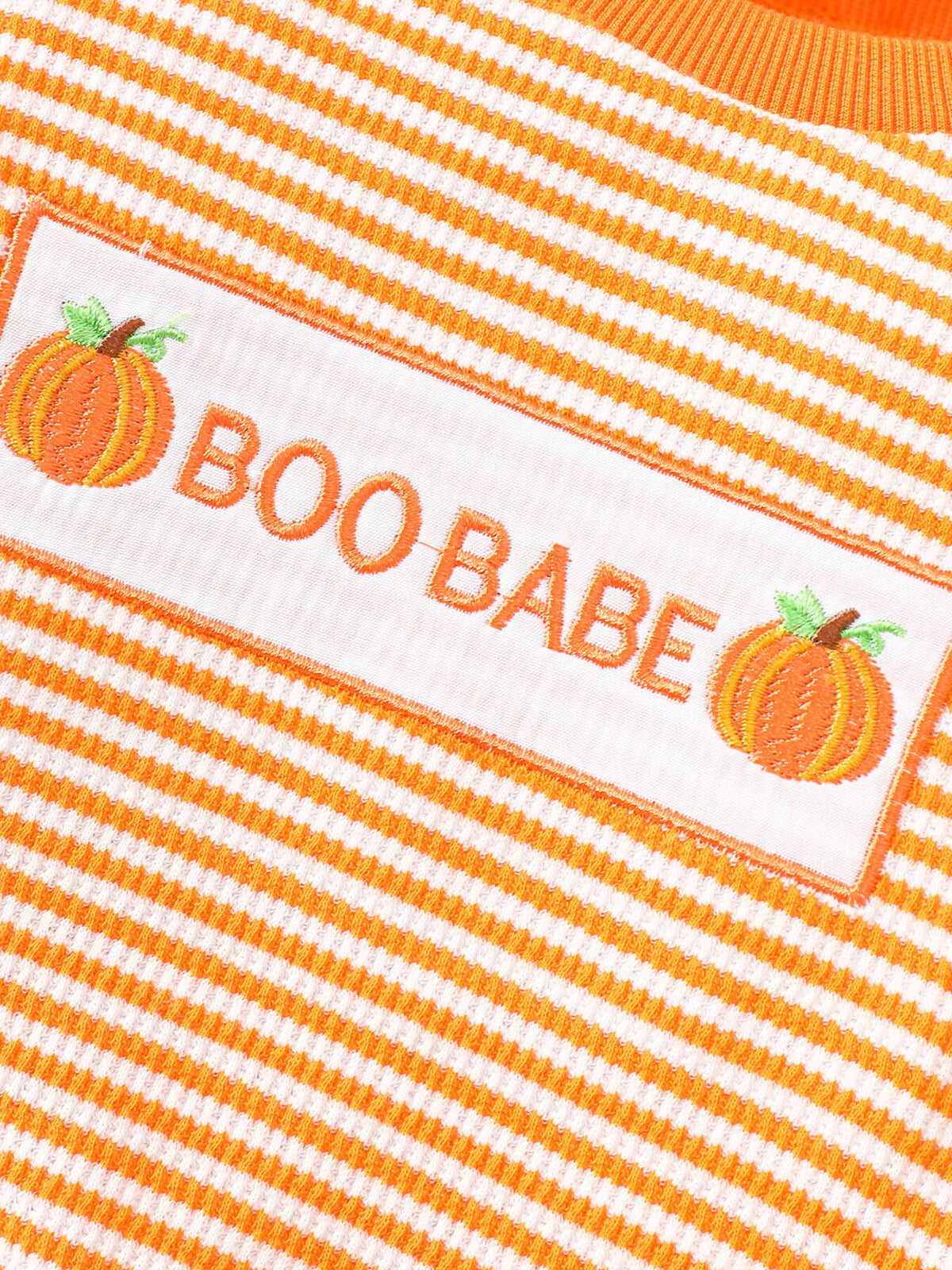 BOO BABE lettering and pumpkin graphics on orange-striped pajama fabric