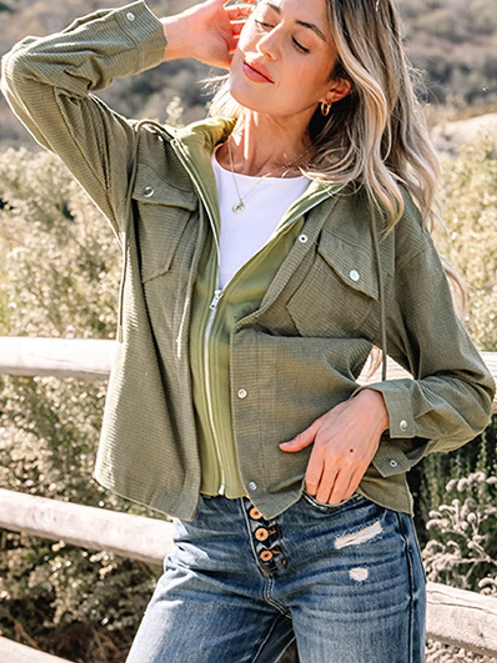 Matcha-green hooded jacket modeled outdoors.