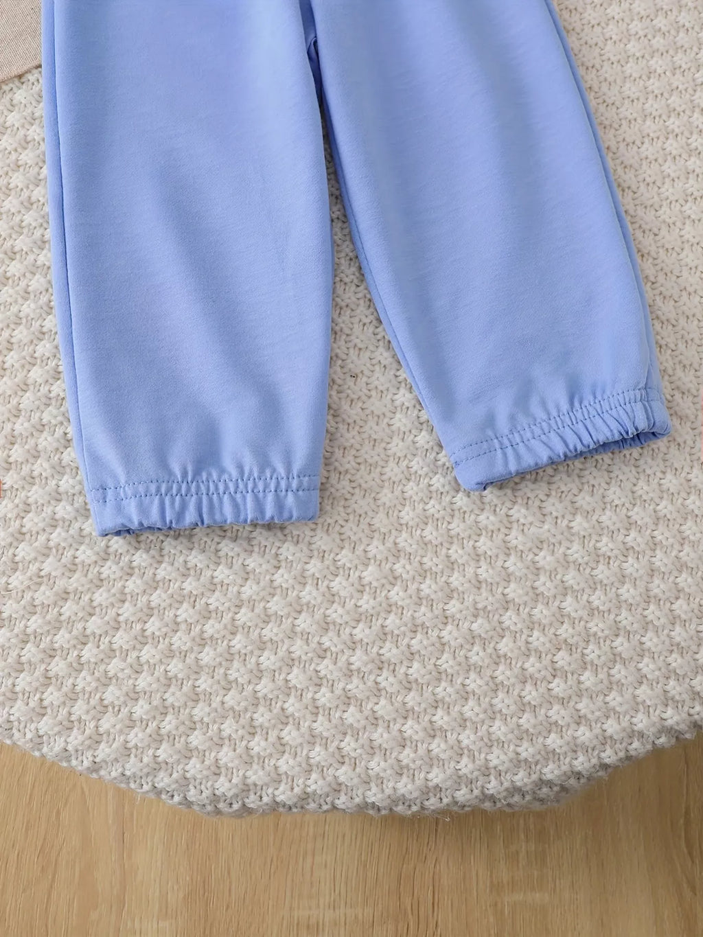 Close-up of the light blue jogger pants' elastic ankle cuffs.