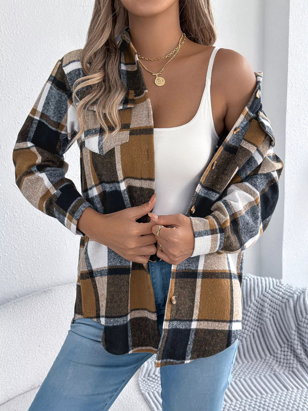 Khaki plaid button-down shacket with chest pockets, worn open over a white top.