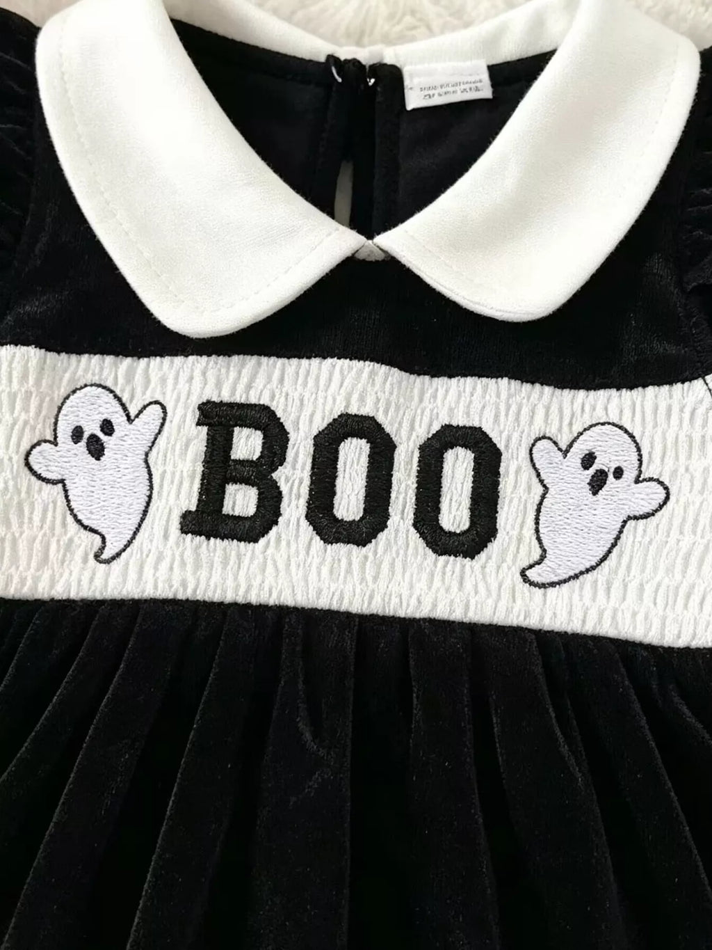 Close-up of the white Boo waistband and ghost designs on the black romper.