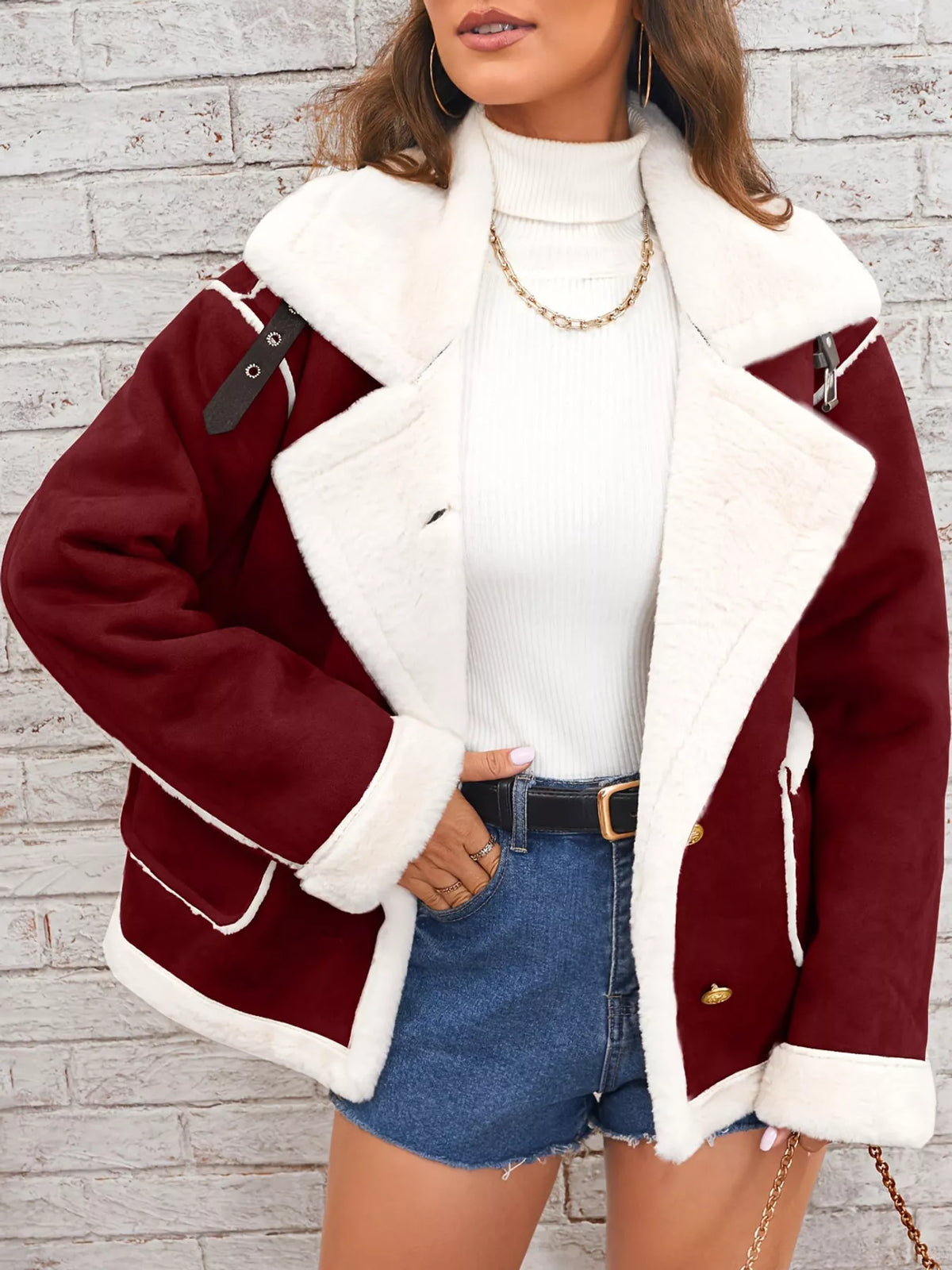 Crimson jacket with wide white plush lapels, contrast trim and front pockets, front view modeled with a hand at the hip.