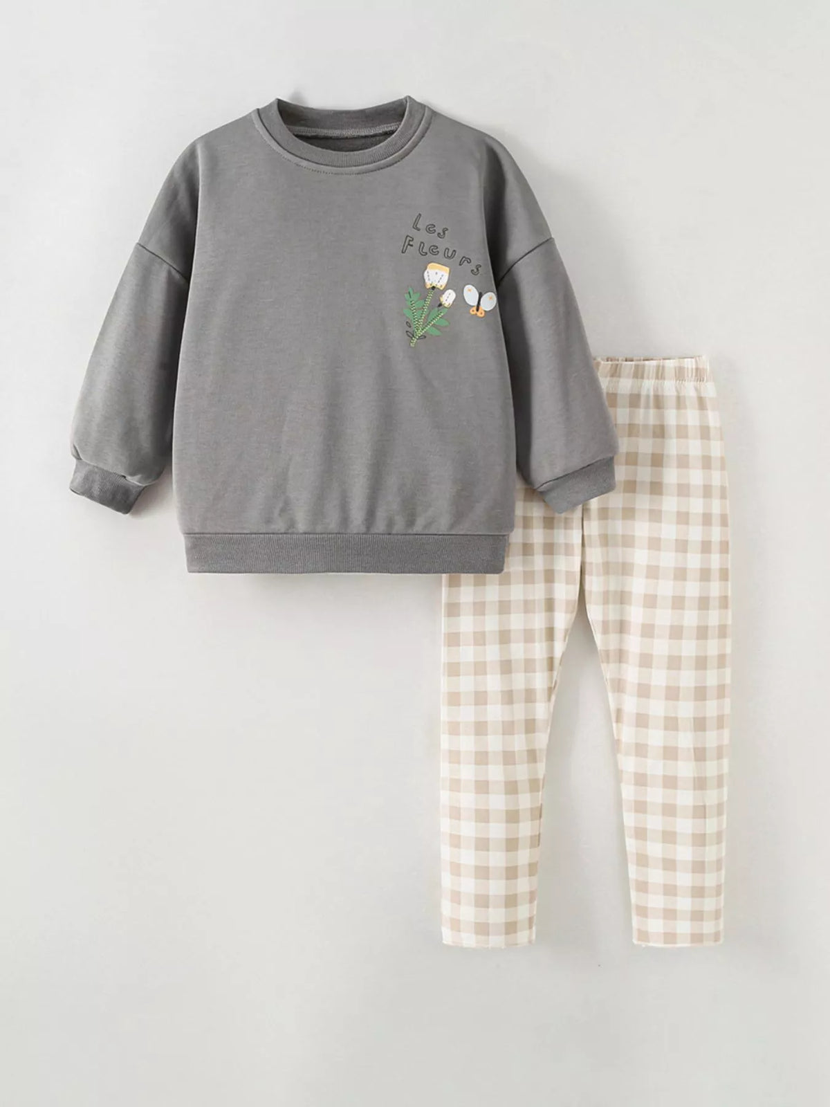 Gray graphic sweatshirt and beige plaid pants displayed flat
