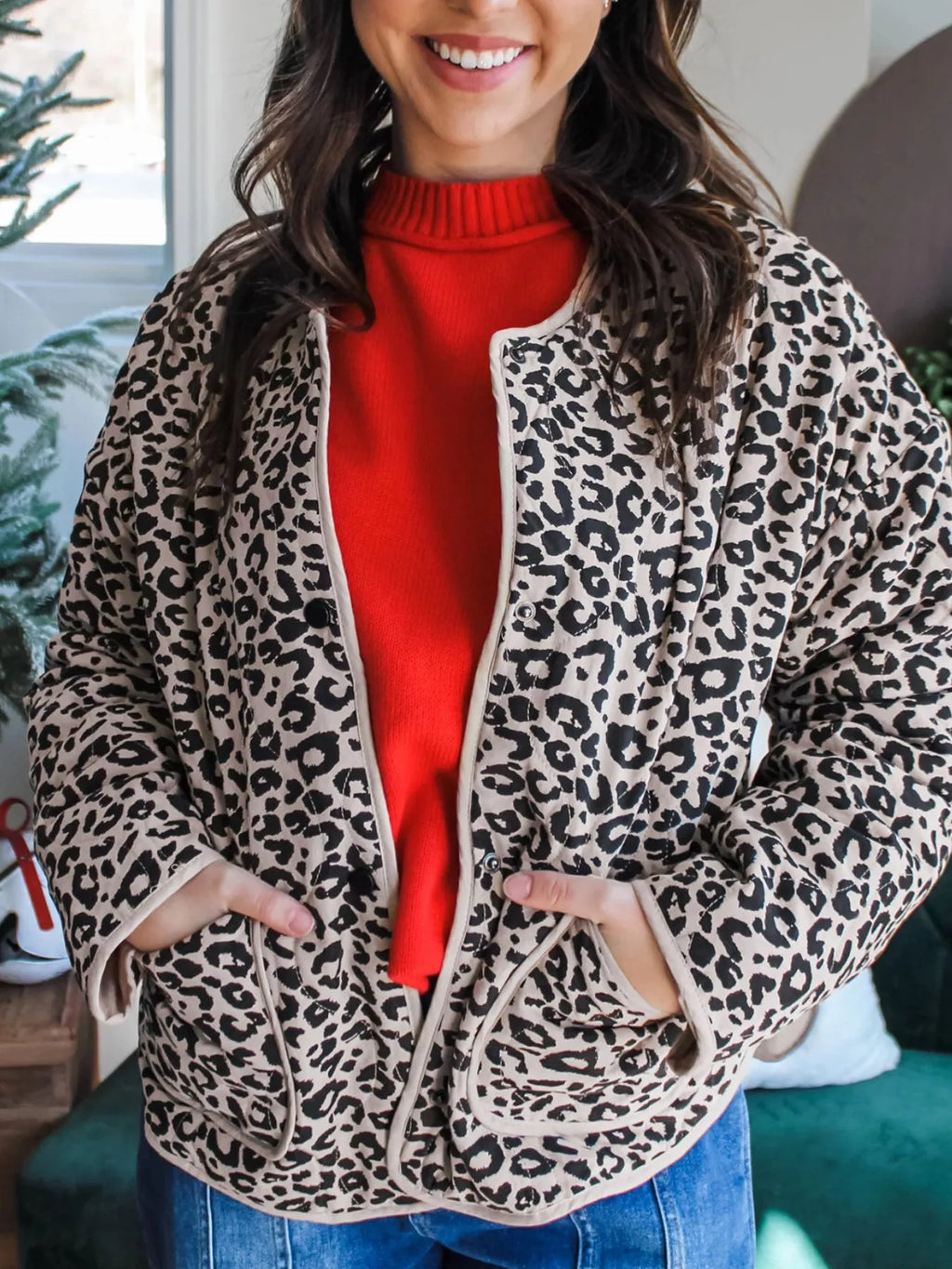 Leopard-print jacket with contrast binding and patch pockets, worn over a red top.
