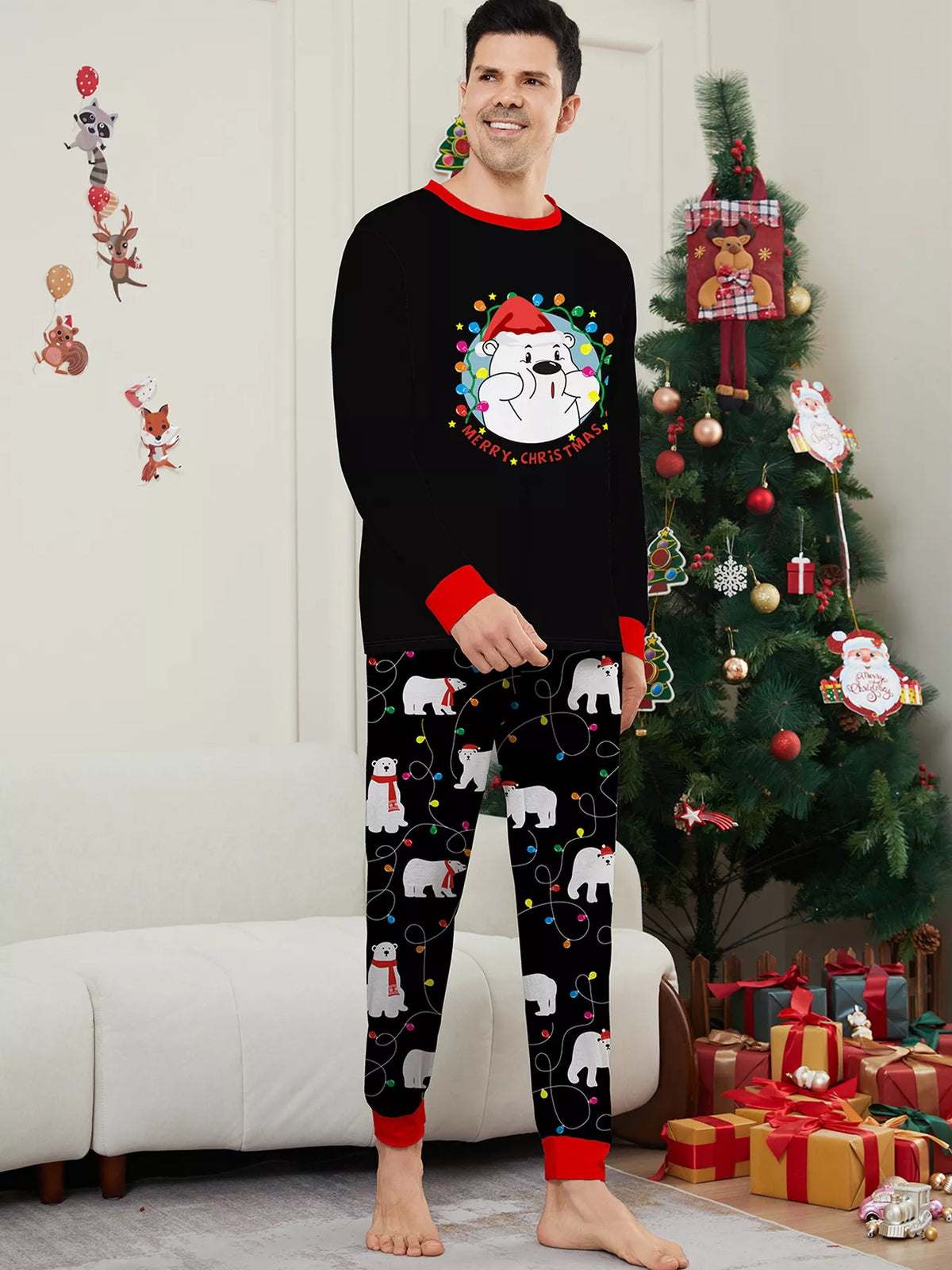 Man modeling a black Christmas graphic top and black polar-bear-print pajama pants.
