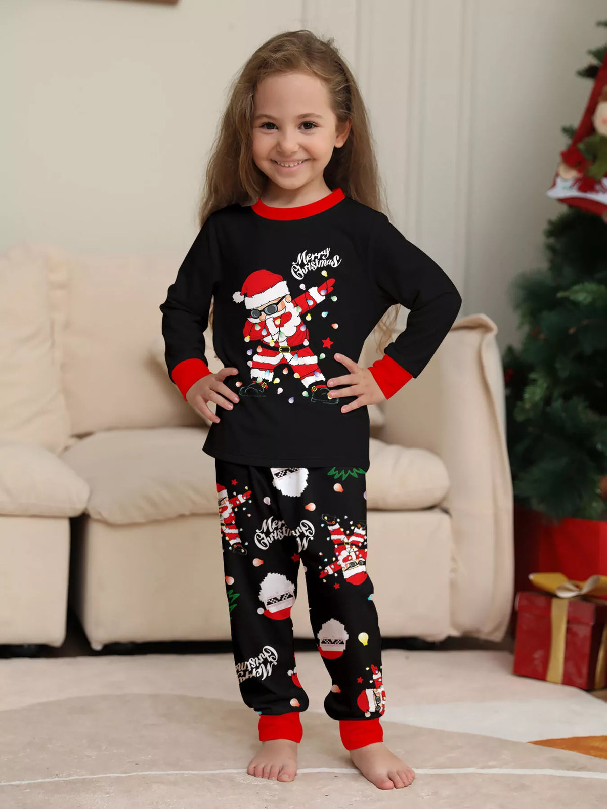 Child wearing the black Santa graphic top and printed pants with red cuffs.