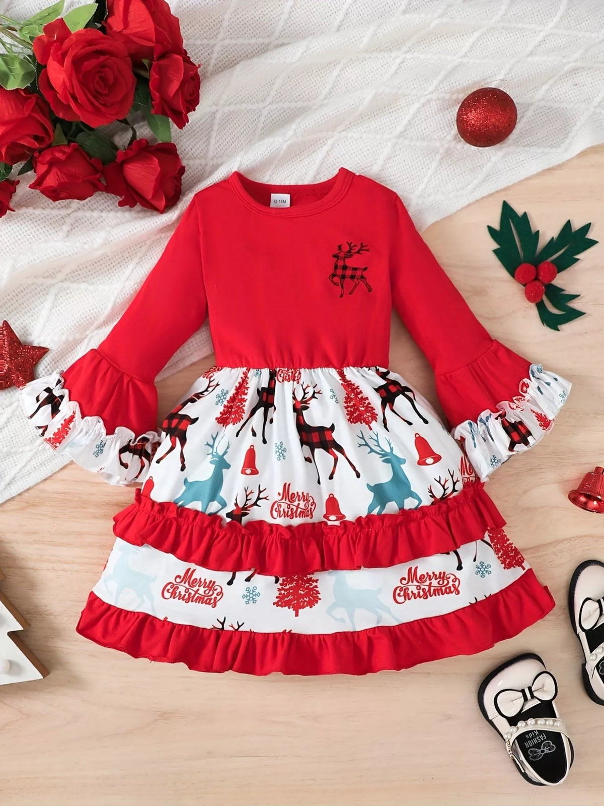 Front flat lay of the red long-sleeve reindeer-print Christmas dress with tiered ruffles.