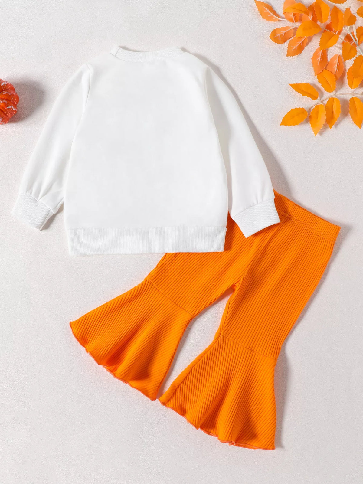 Back flat lay of the white top and orange ribbed flared pants.