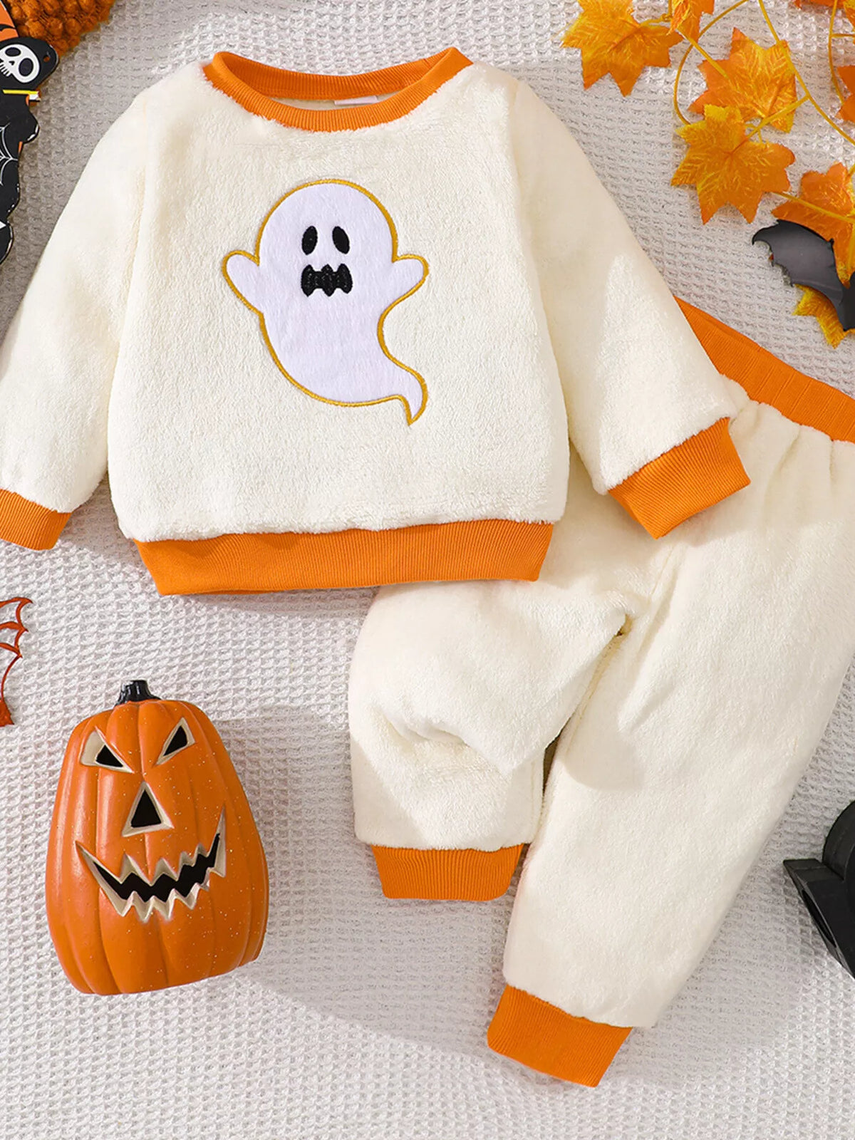 Cream ghost graphic top with orange trim and matching pants displayed flat