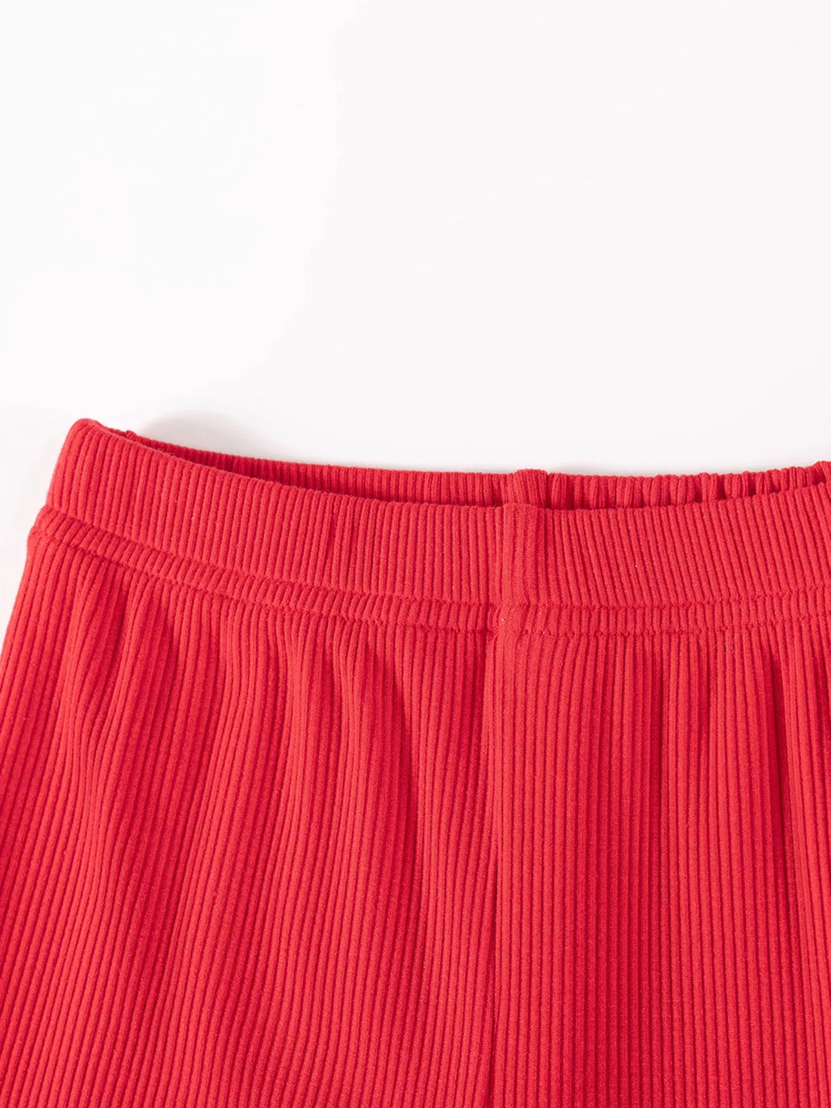 Close-up of the red ribbed pants' elastic waistband.