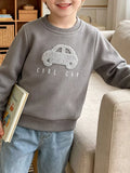 Child wearing a gray sweatshirt with textured car applique and Cool Car lettering.