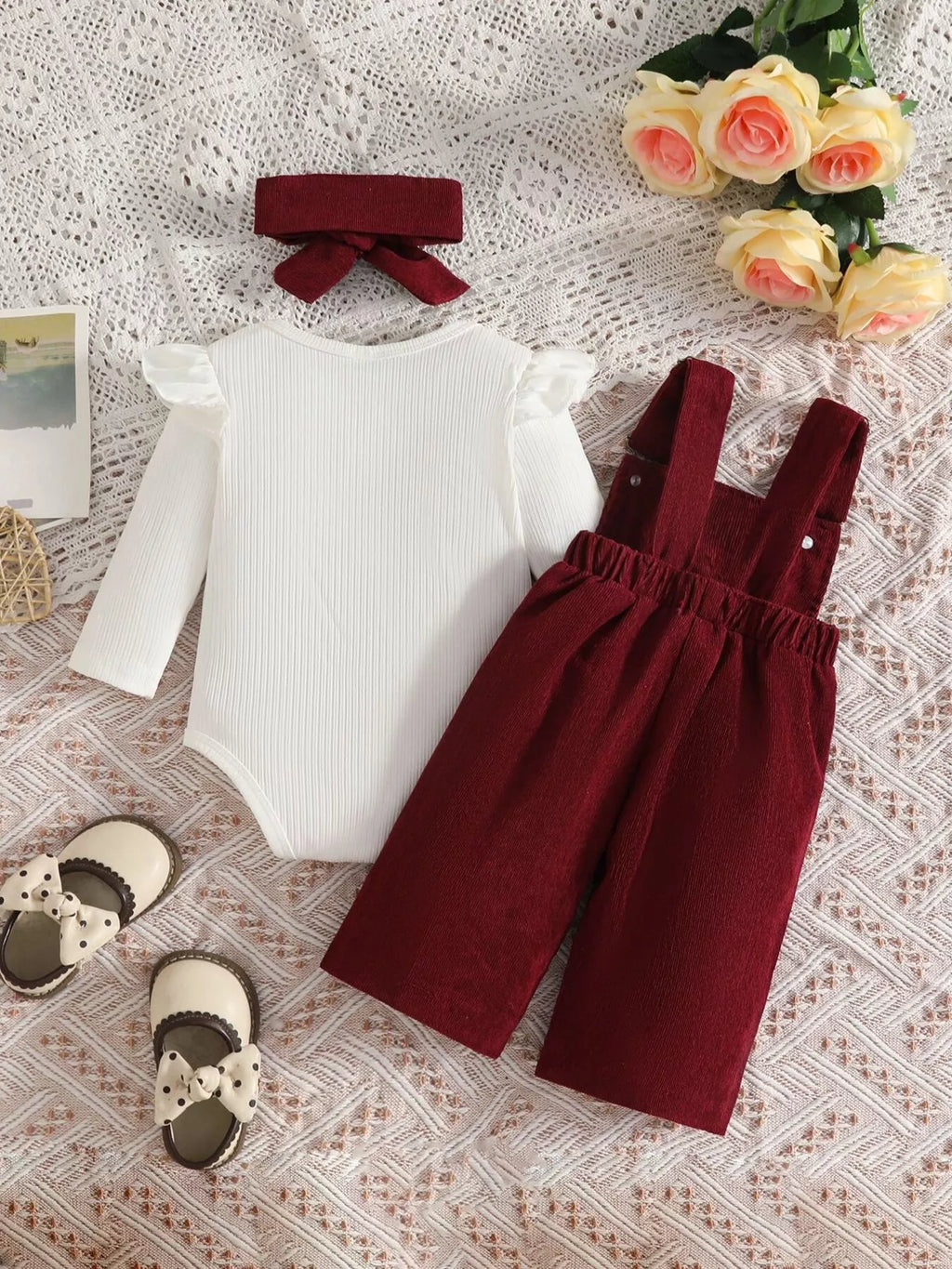 White ribbed baby bodysuit with burgundy bow-embroidered overalls and matching headband displayed flat