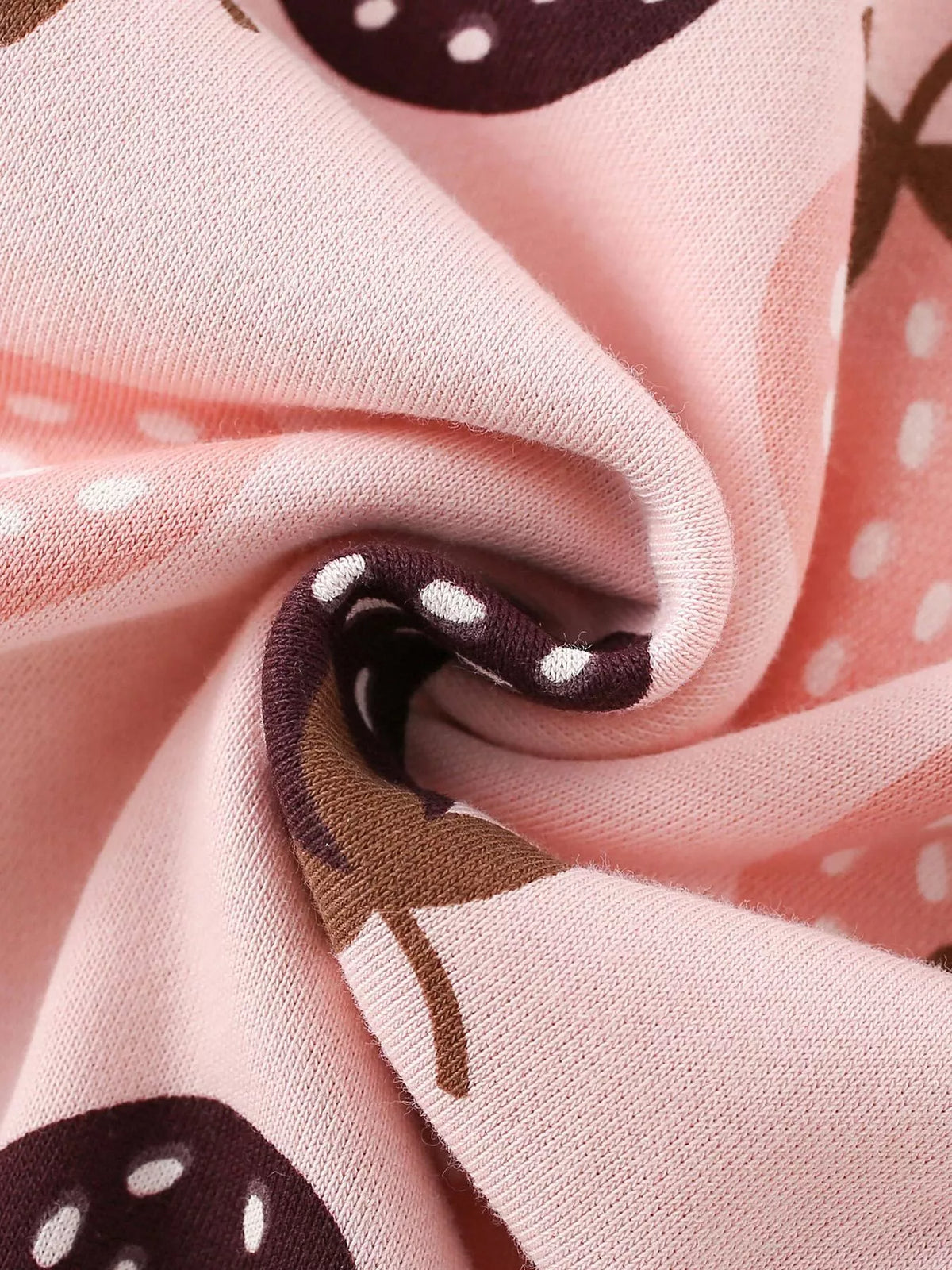 Folded pink strawberry-print sweatshirt fabric.