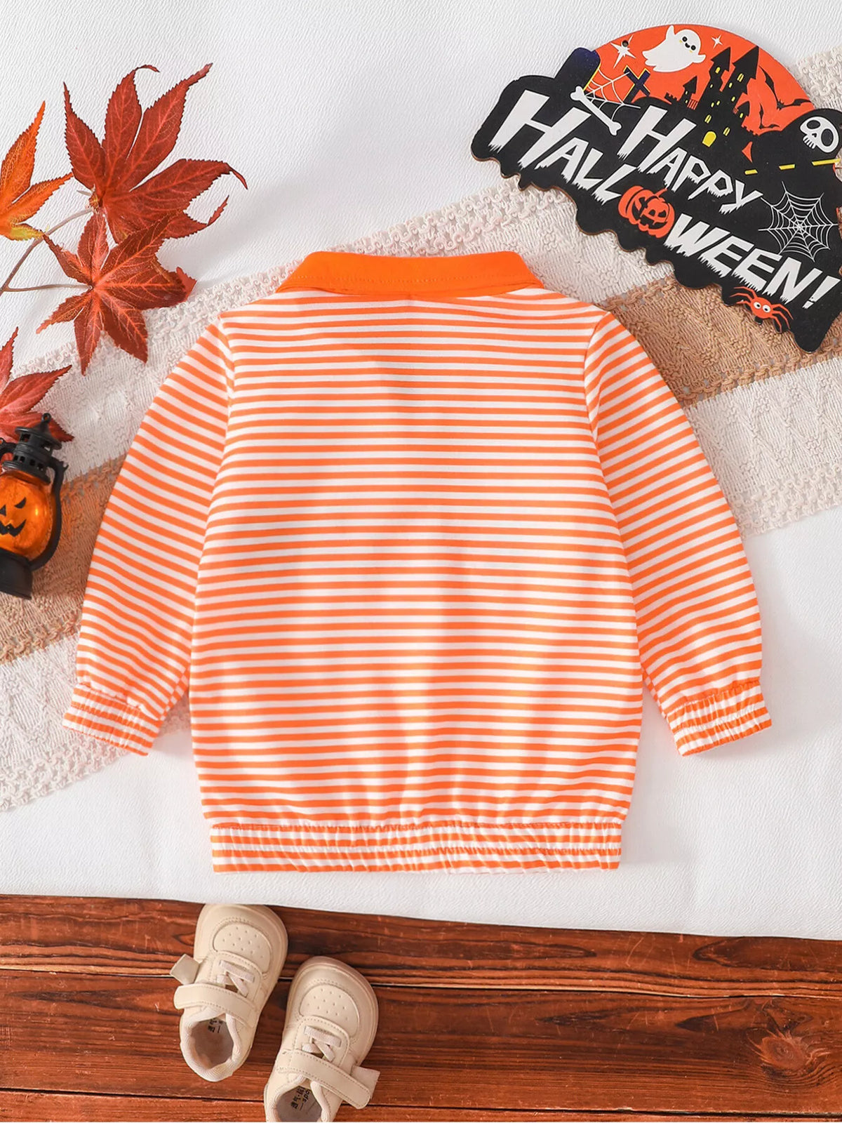 Back flat lay of the orange-and-white striped children's top.