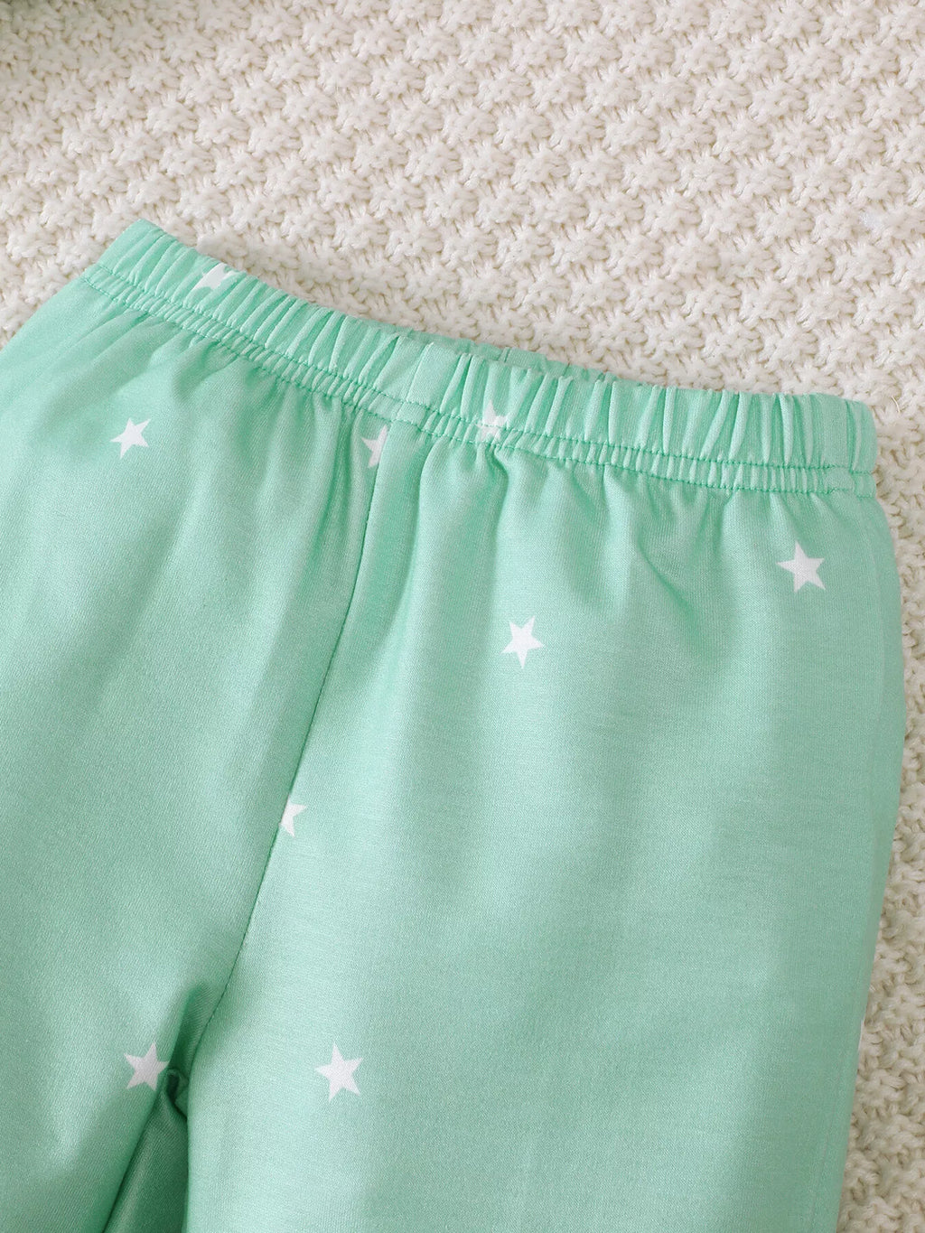 Close-up of the mint star-print pants' elastic waistband.