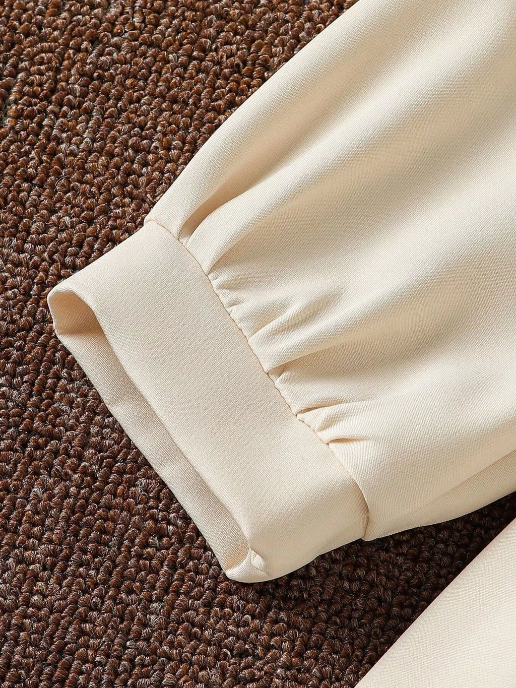 Close-up of the cream dress's gathered sleeve cuff.