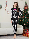 Woman modeling black pajamas with white skeleton graphics and a pink bow.