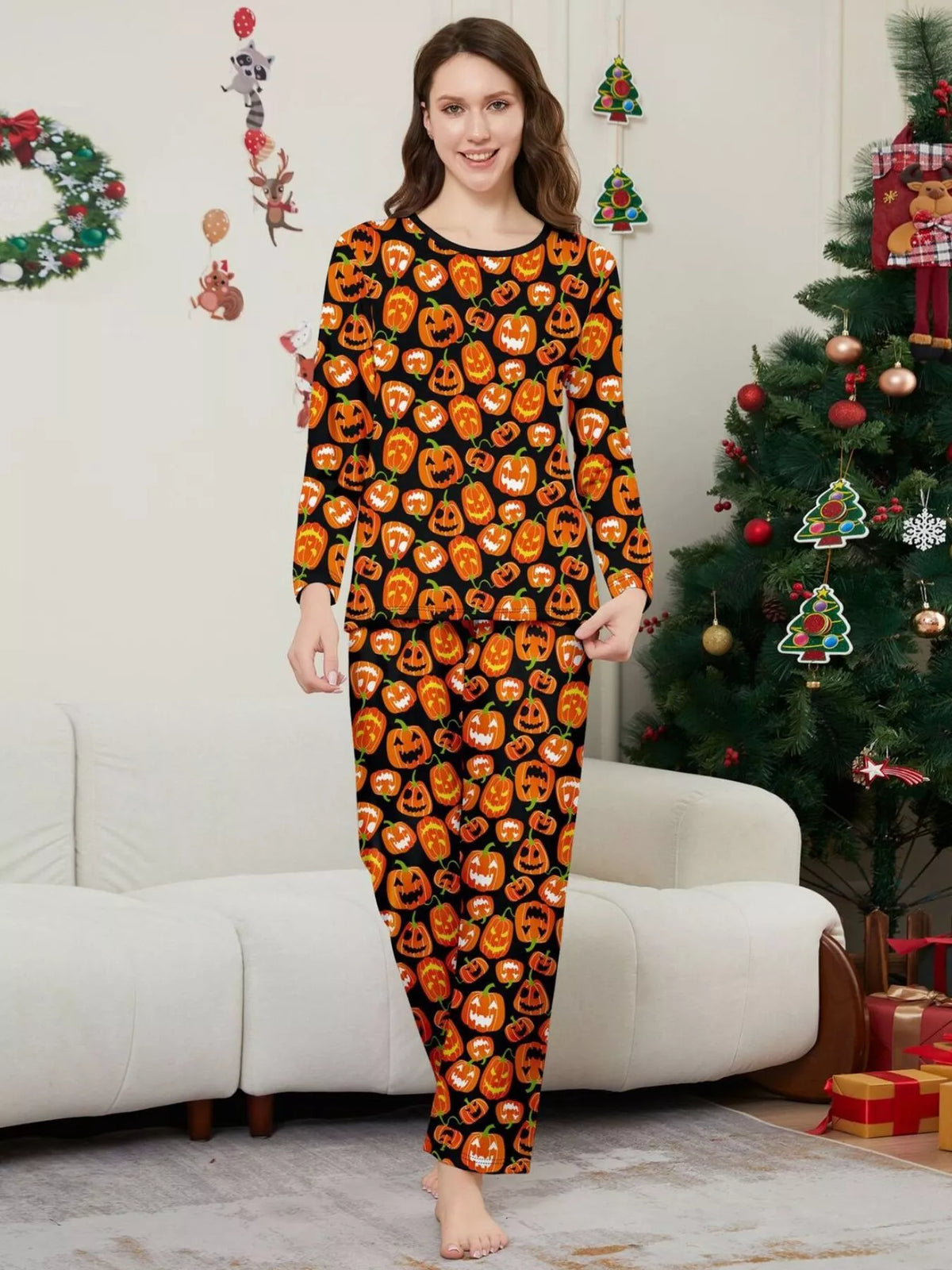 Woman modeling the black and orange pumpkin-print pajama set.