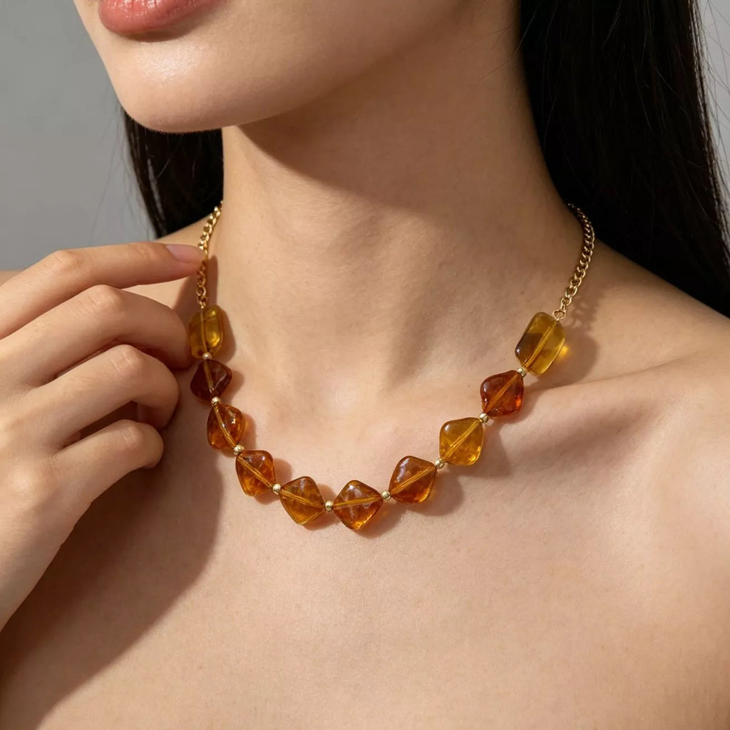 Gold-tone necklace with angular amber-colored beads — detail view