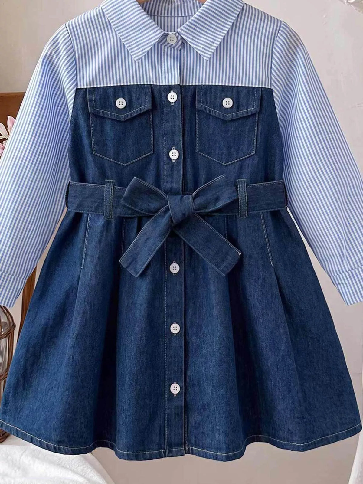 Front view of the blue button-front dress with striped sleeves, chest pockets and tied belt.