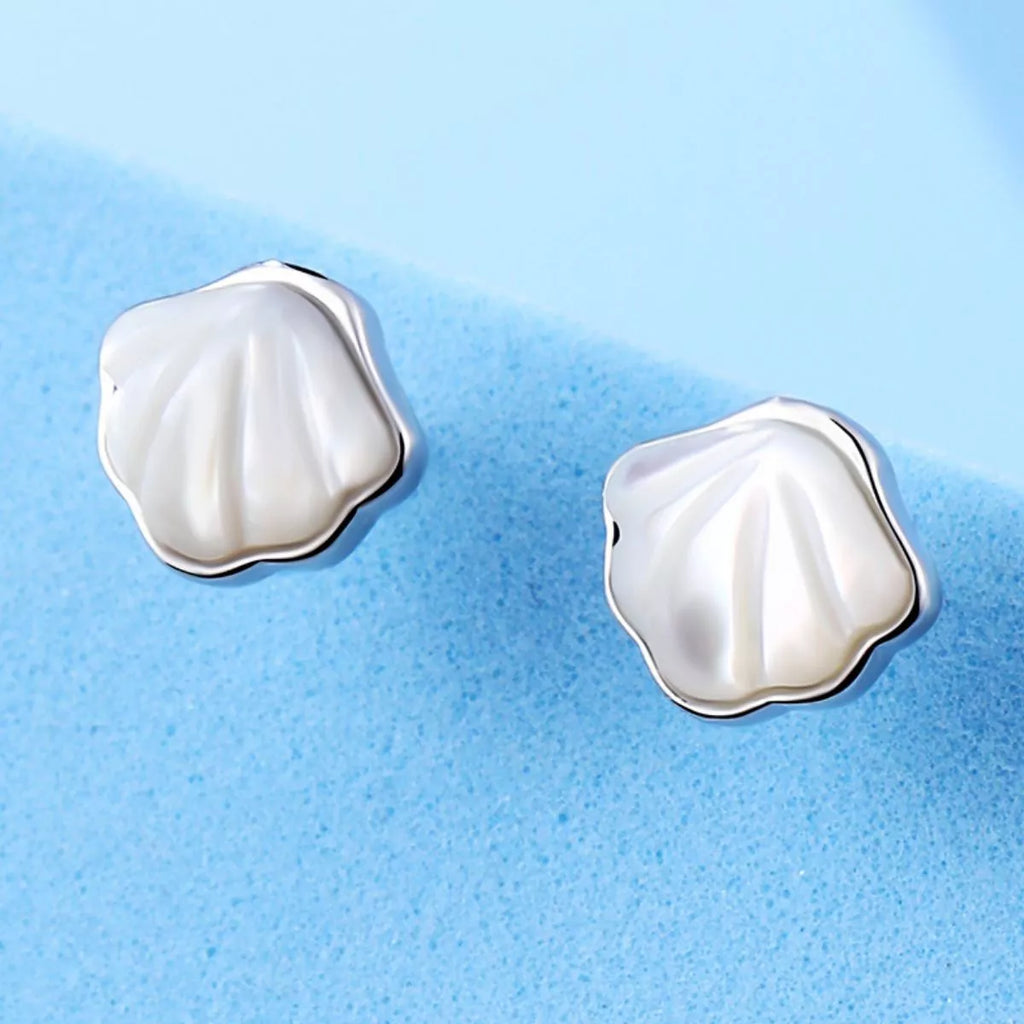Silver-tone shell-shaped stud earrings with white centers — detail view