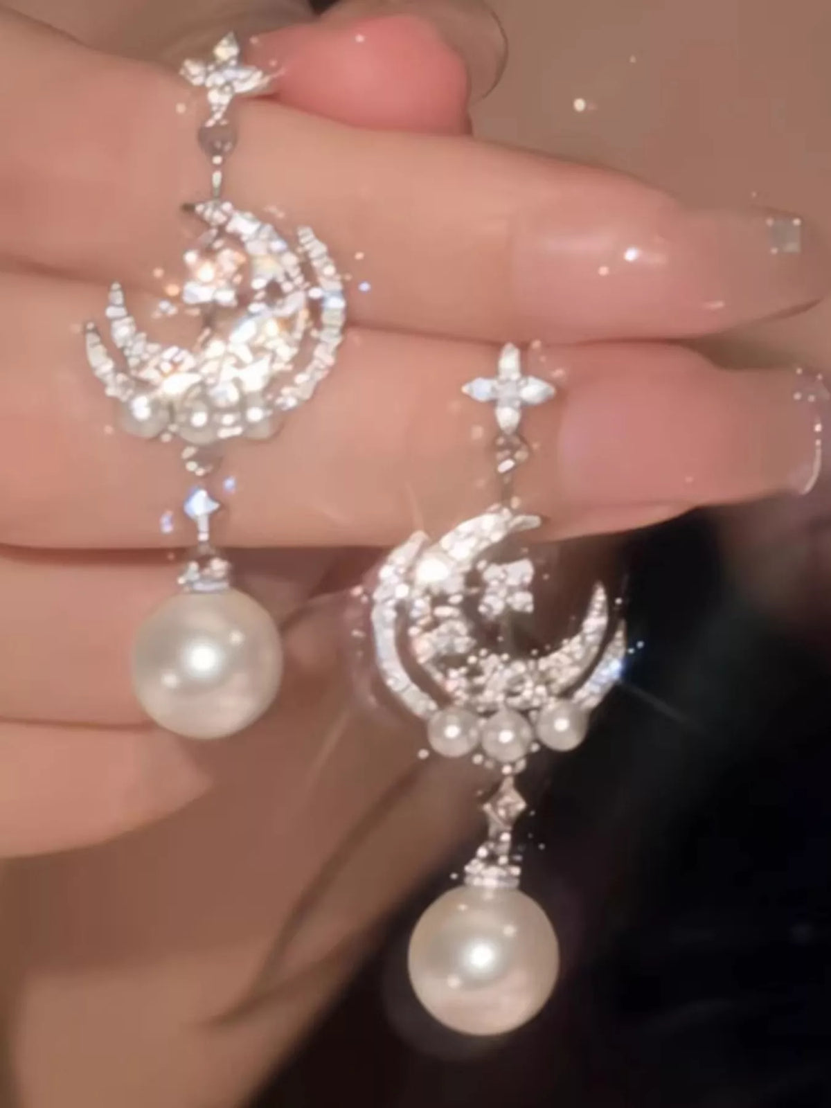 Moon and star dangle earrings with pearl-like bead drops — detail view