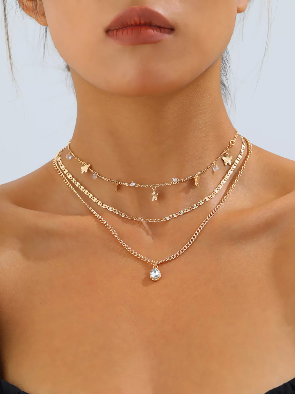Layered gold-tone necklace with butterfly and clear stone charms