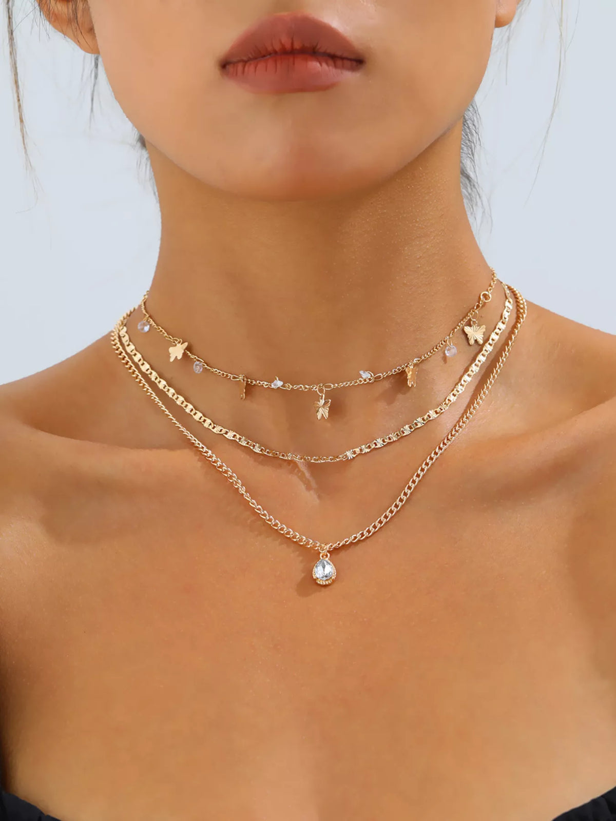 Layered gold-tone necklace with butterfly and clear stone charms