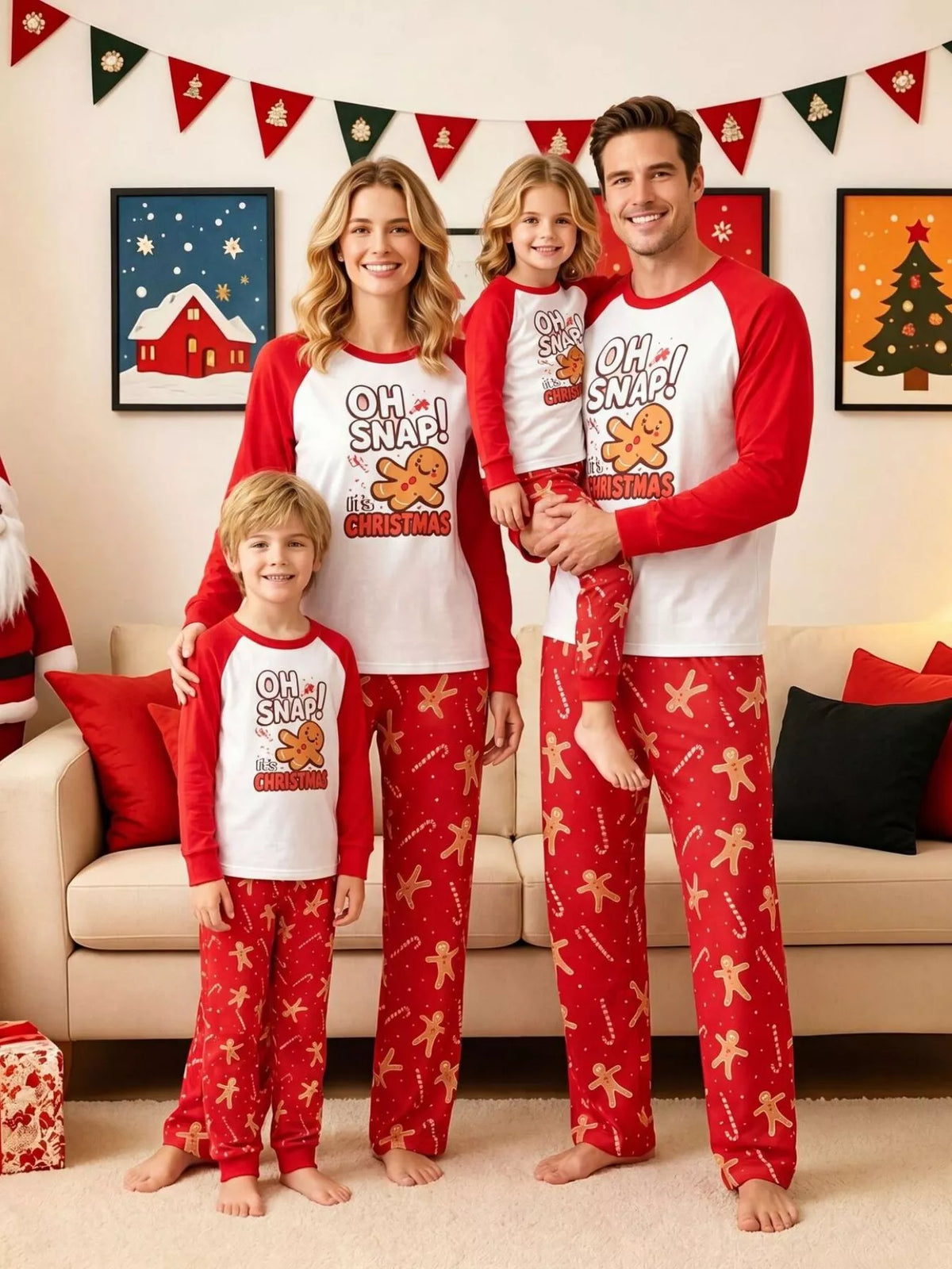Family wearing matching white Oh Snap gingerbread graphic tops with red sleeves and red printed pajama pants.