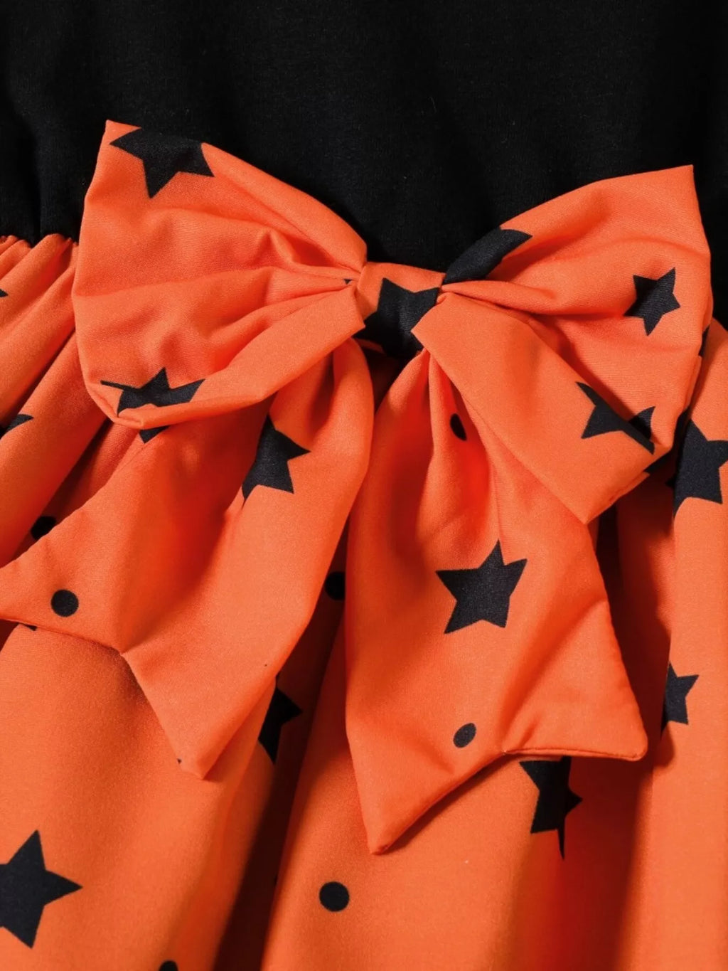 Large orange waist bow with black stars on the Halloween dress