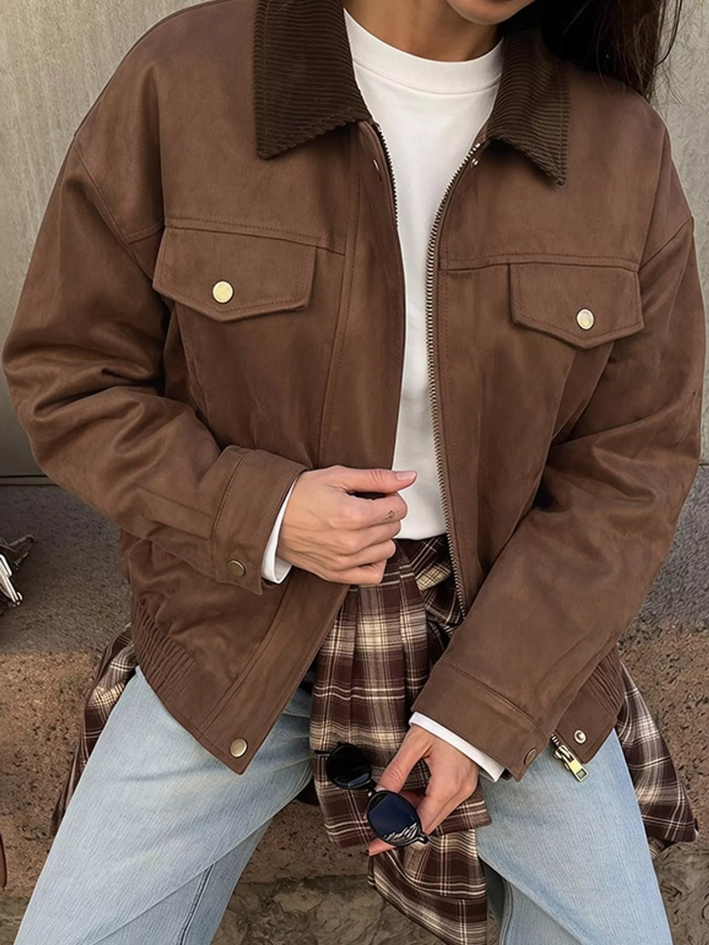 Front detail of the brown jacket's contrast collar, zip front and buttoned flap pockets.