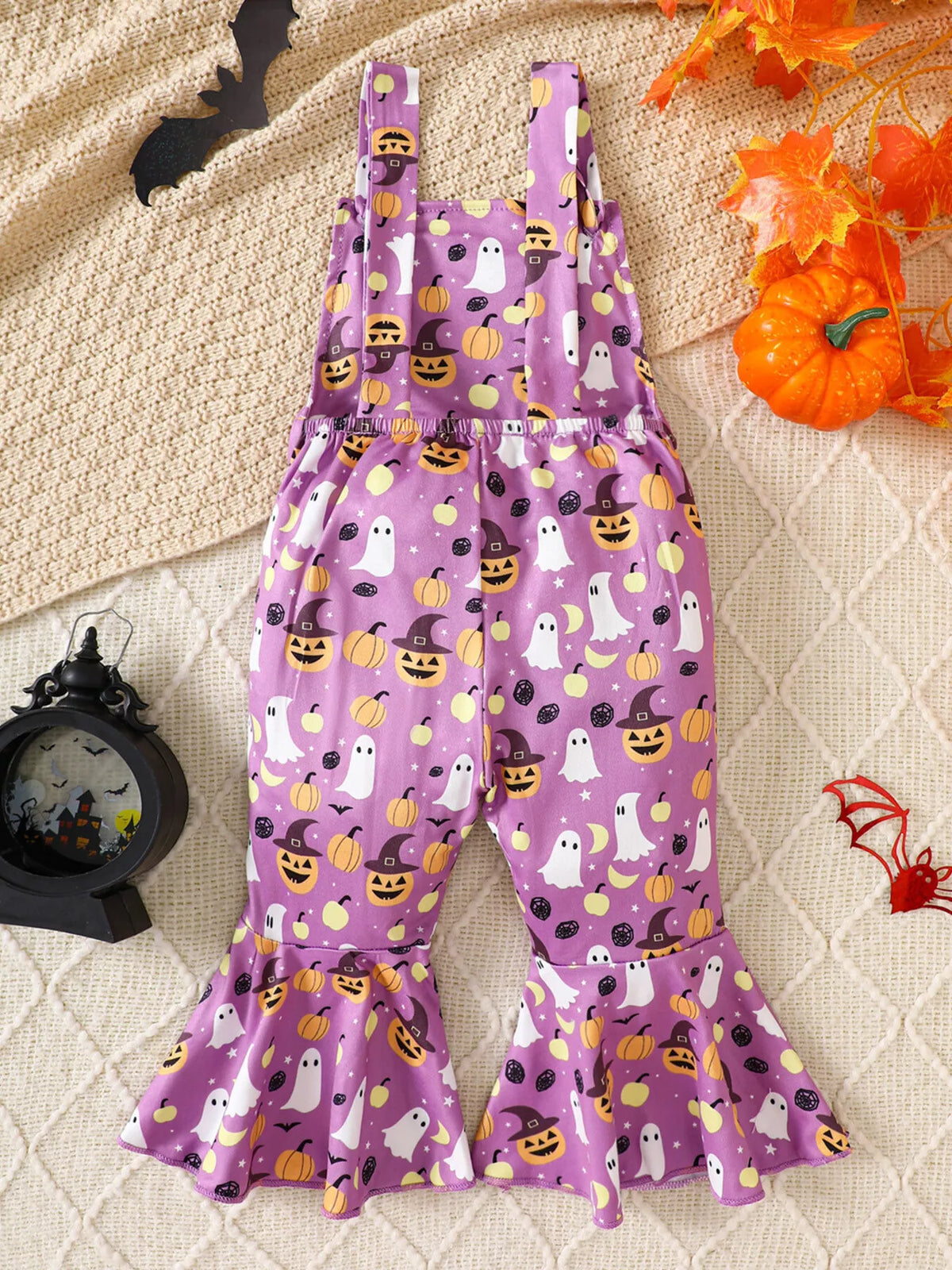 Back view of the purple Halloween-print flared suspender overalls.