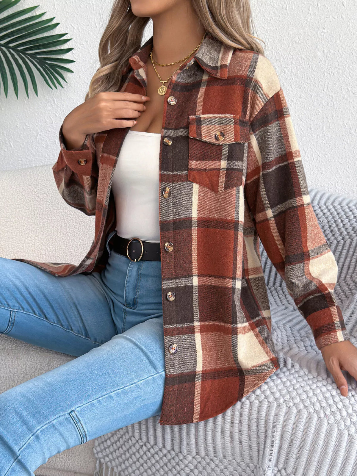 Orange plaid button-down shacket with chest pockets, modeled seated with jeans.