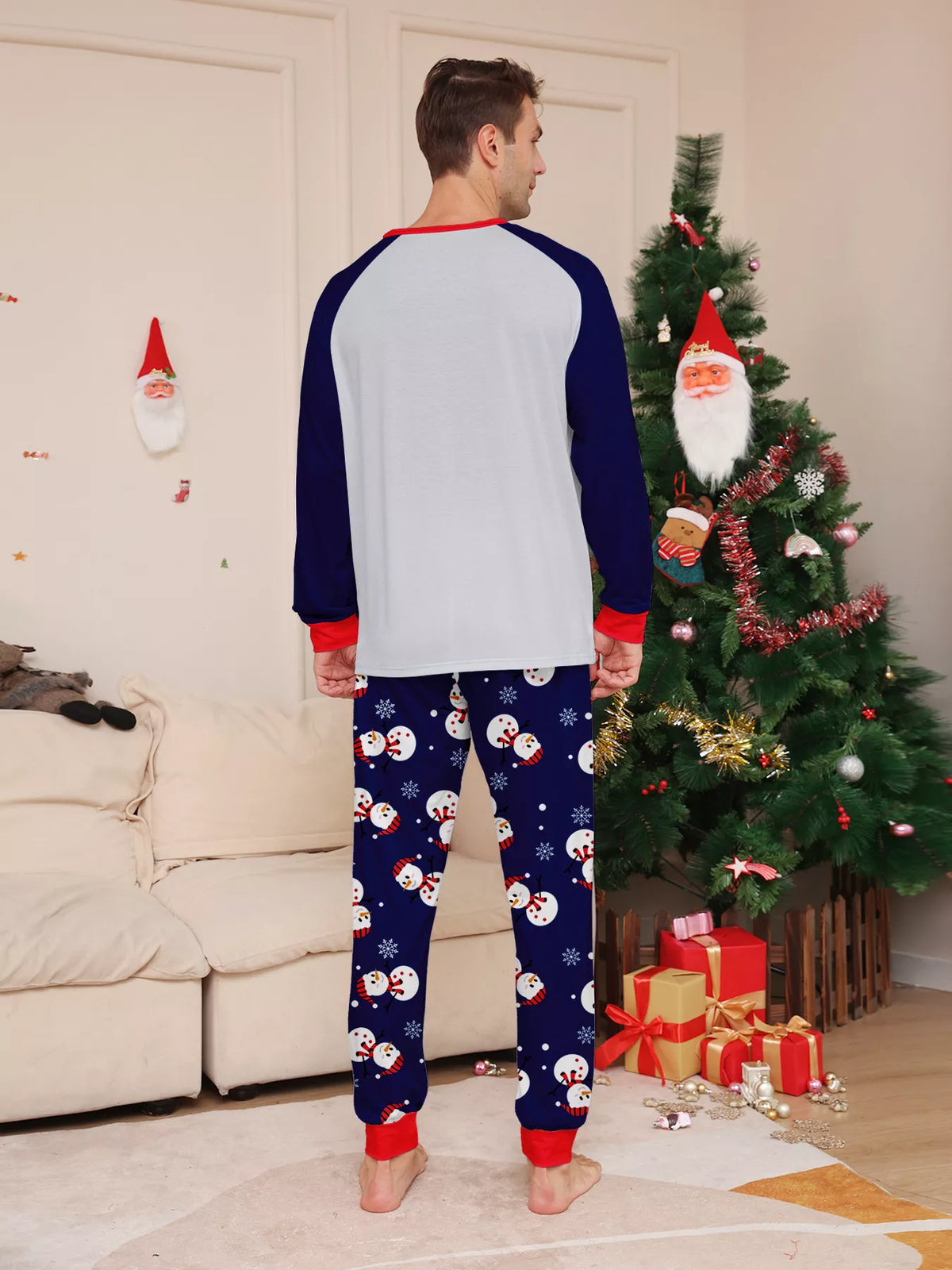 Back view of the men's white top with navy sleeves and snowman-print pants.
