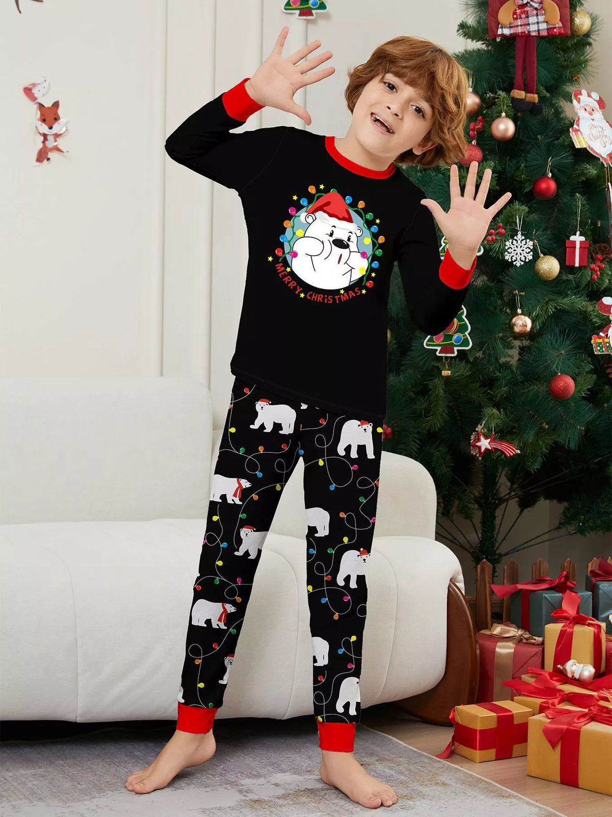 Child modeling the black Christmas graphic top and polar-bear-print pants.