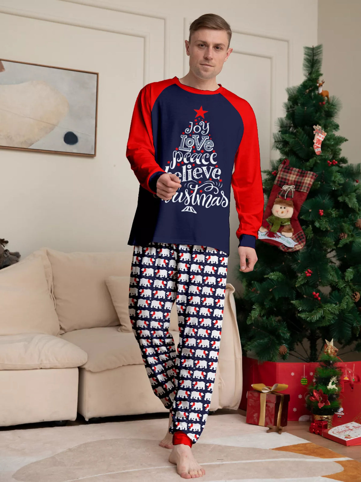 Navy and red Christmas graphic pajama top with matching festive-print pants worn by an adult