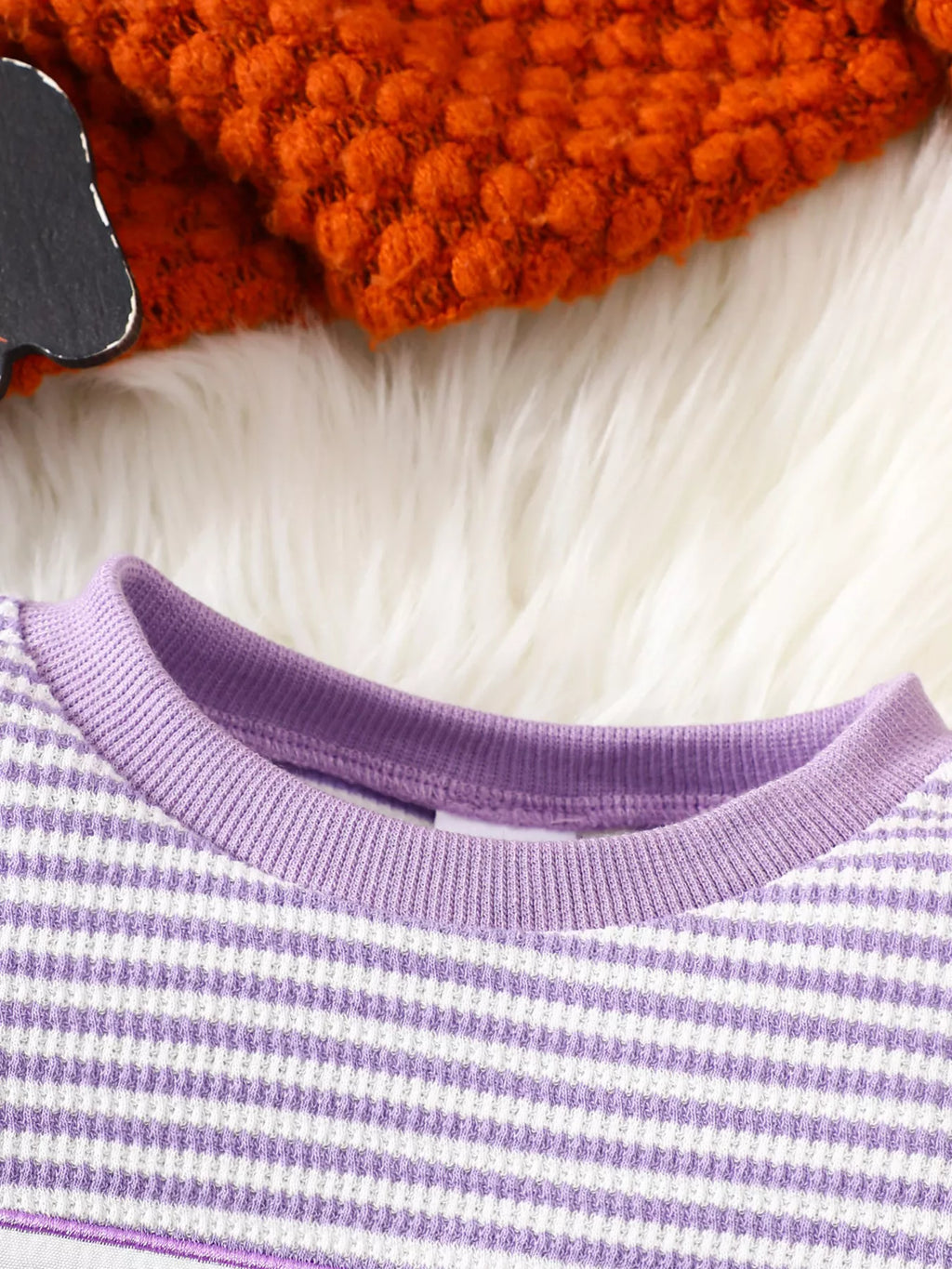 Purple ribbed neckline on the purple-striped pajama top