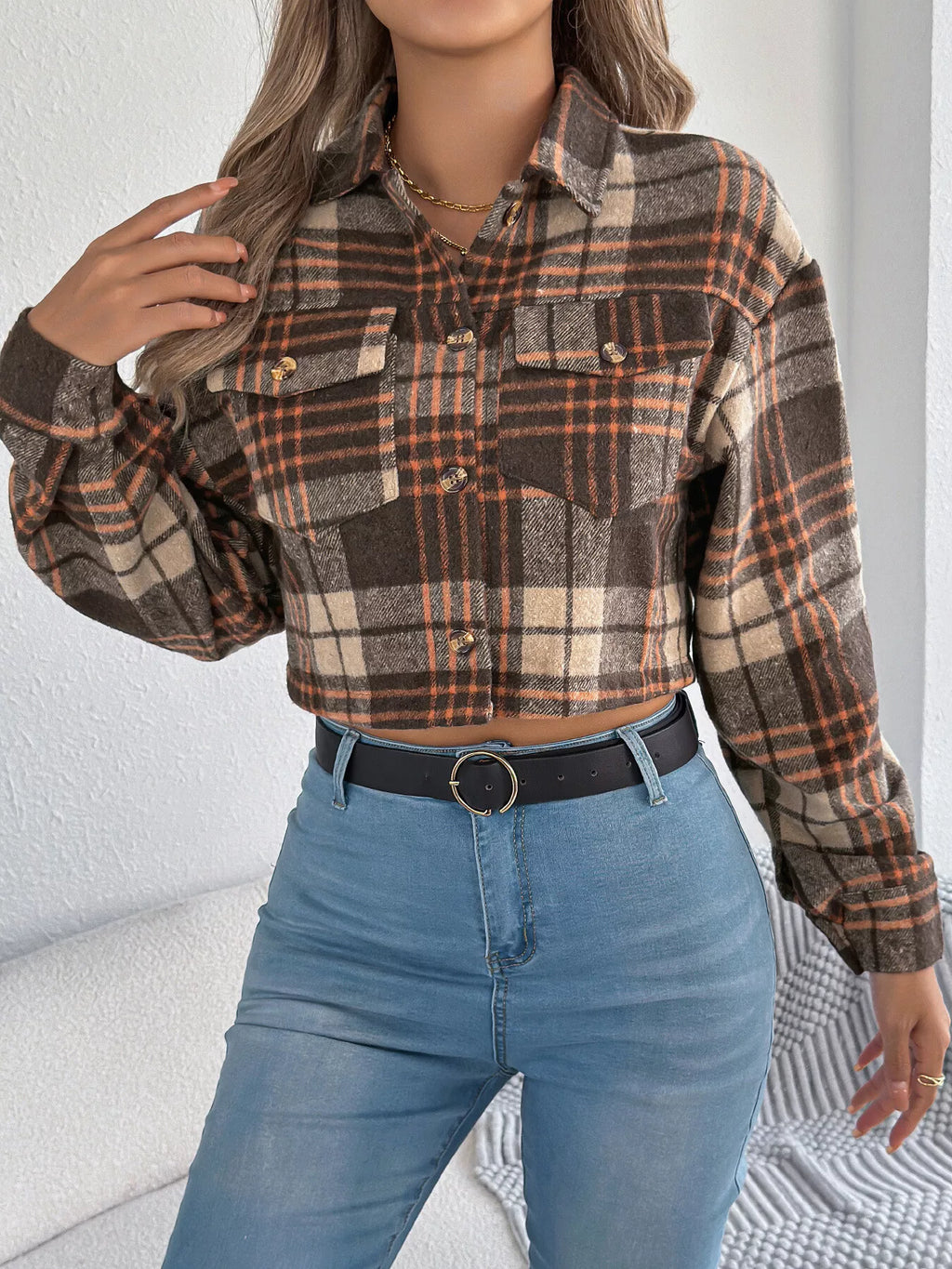 Front view of the brown plaid jacket's button closure and chest pockets.
