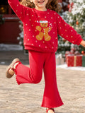 Child wearing a red gingerbread graphic sweatshirt with matching red flared pants.