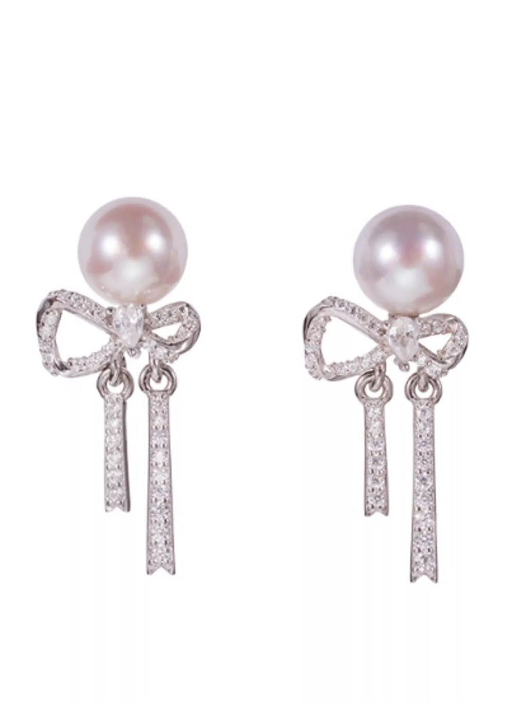 Bow-shaped drop earrings with pearl-like beads and chain tassels — detail view