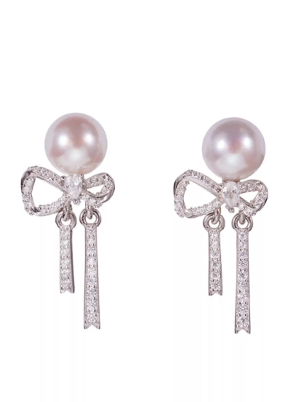 Bow-shaped drop earrings with pearl-like beads and chain tassels — detail view