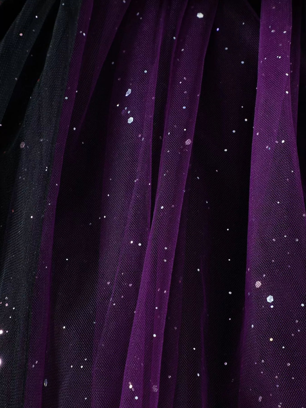 Close-up of black and purple glitter-dotted tulle skirt layers.