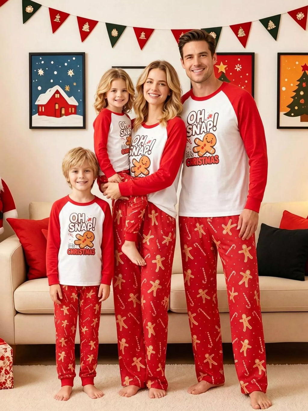 Family wearing matching white Oh Snap gingerbread graphic tops with red sleeves and red printed pajama pants.