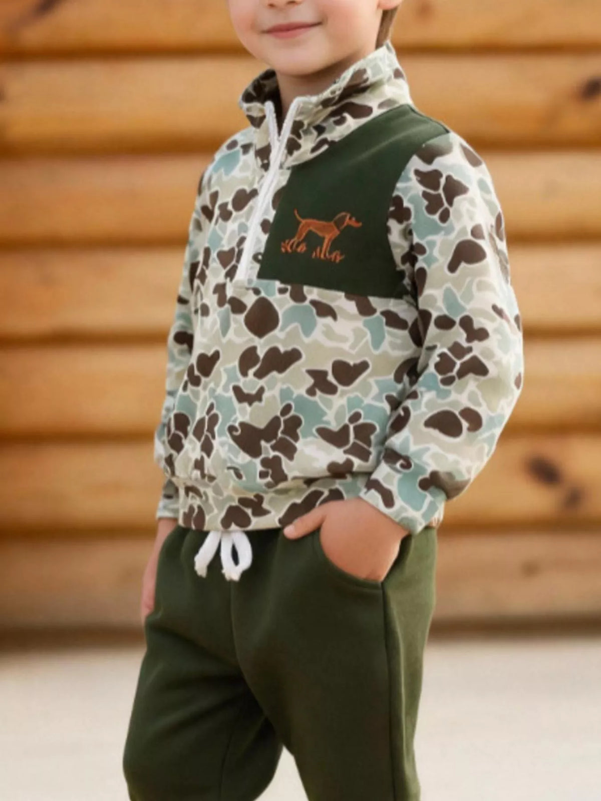 Green camouflage quarter-zip top and olive joggers worn by a child
