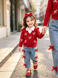 Children’s red bow-embellished sweater with white collar and blue jeans with red bows worn by a child