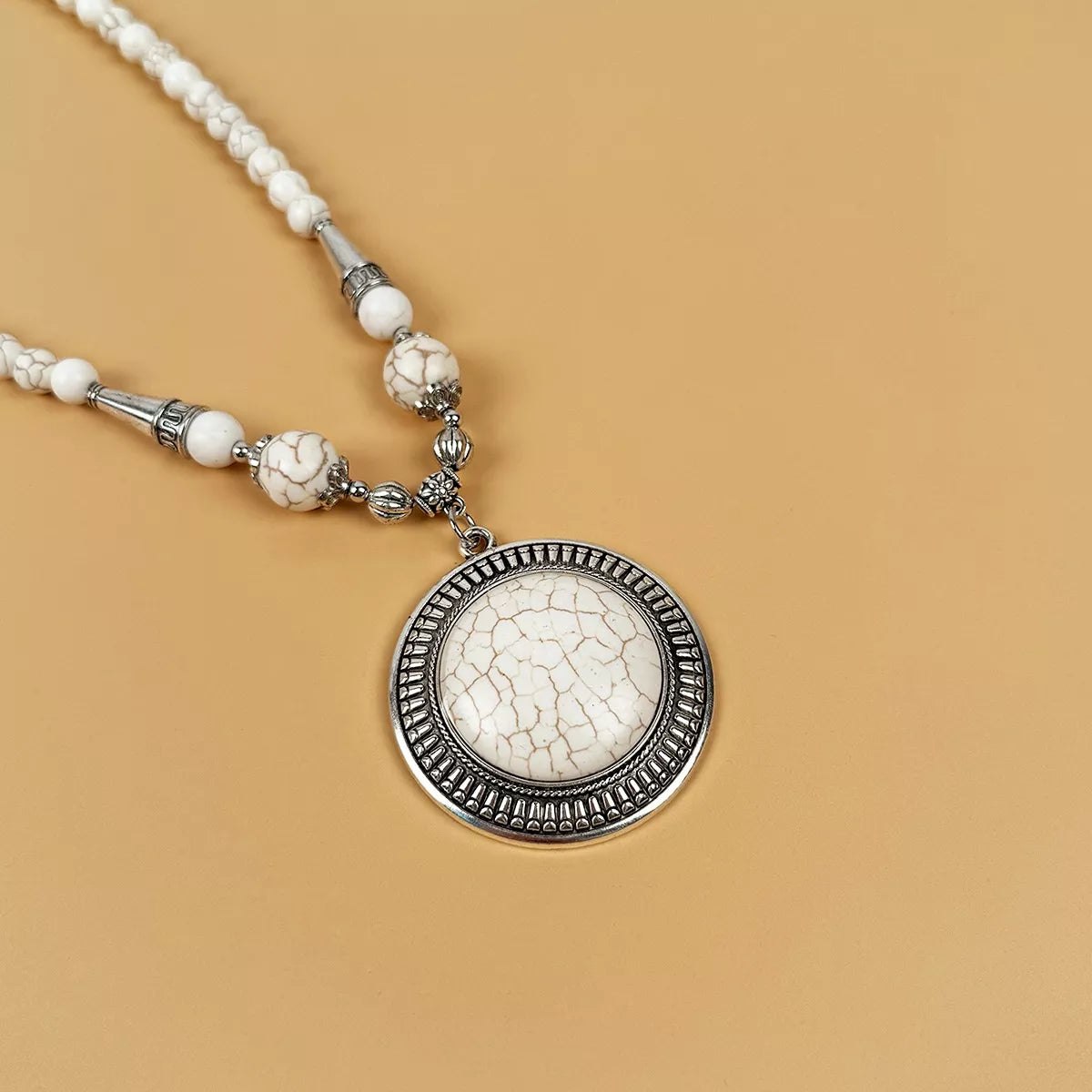 Round medallion pendant necklace with large beads — detail view