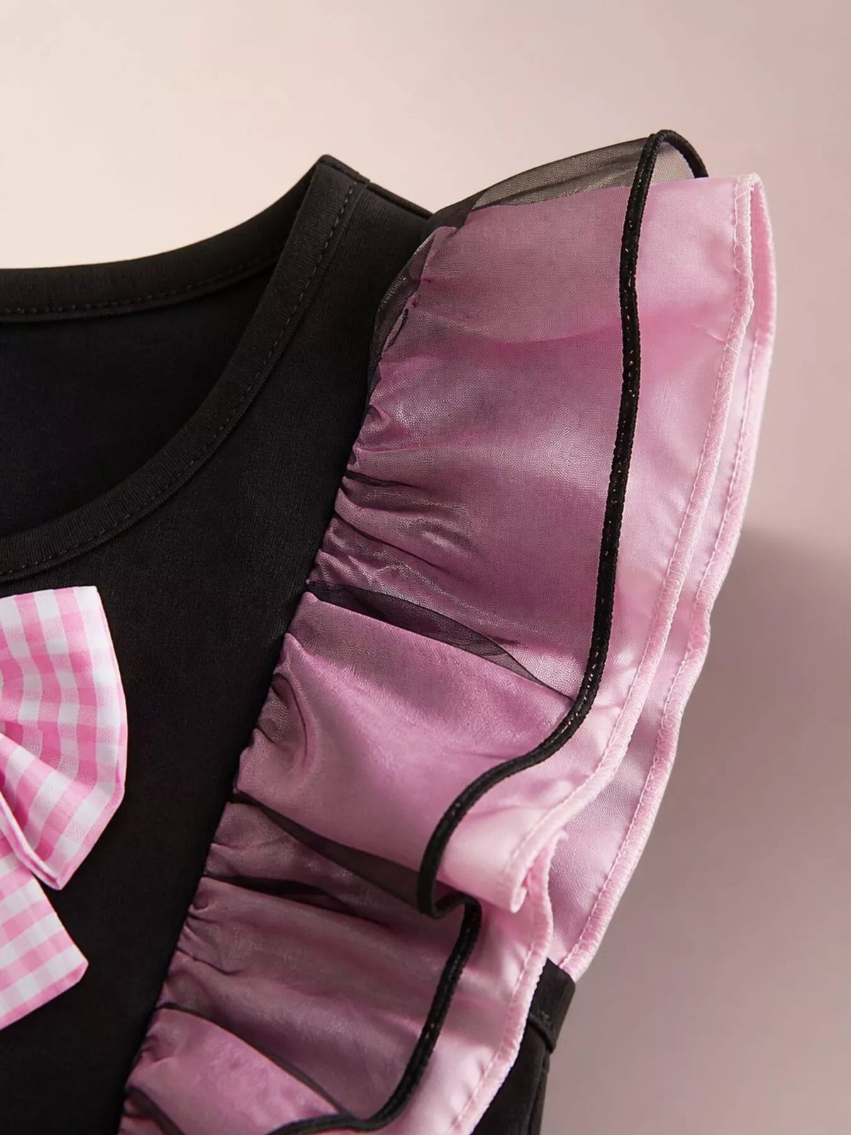 Close-up of the dress's sheer pink-and-black ruffled shoulder trim.