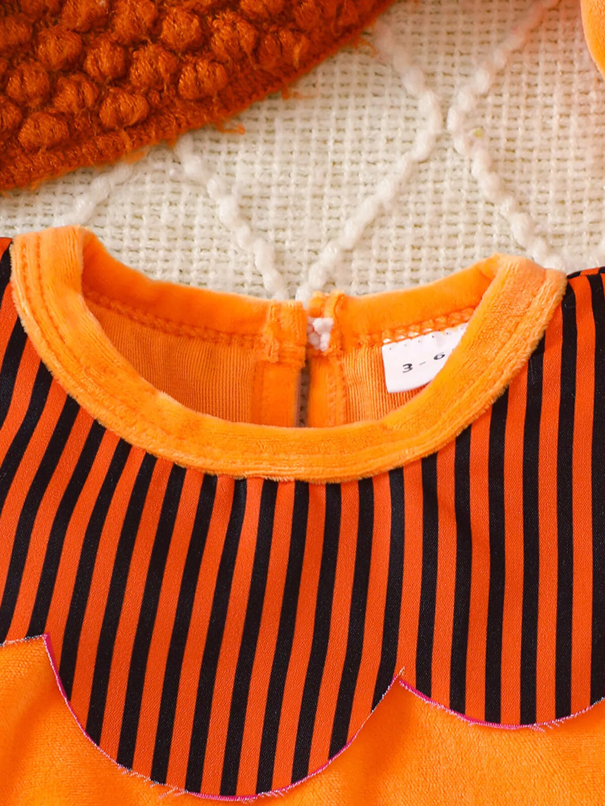 Orange neckline and striped yoke on the orange baby bodysuit