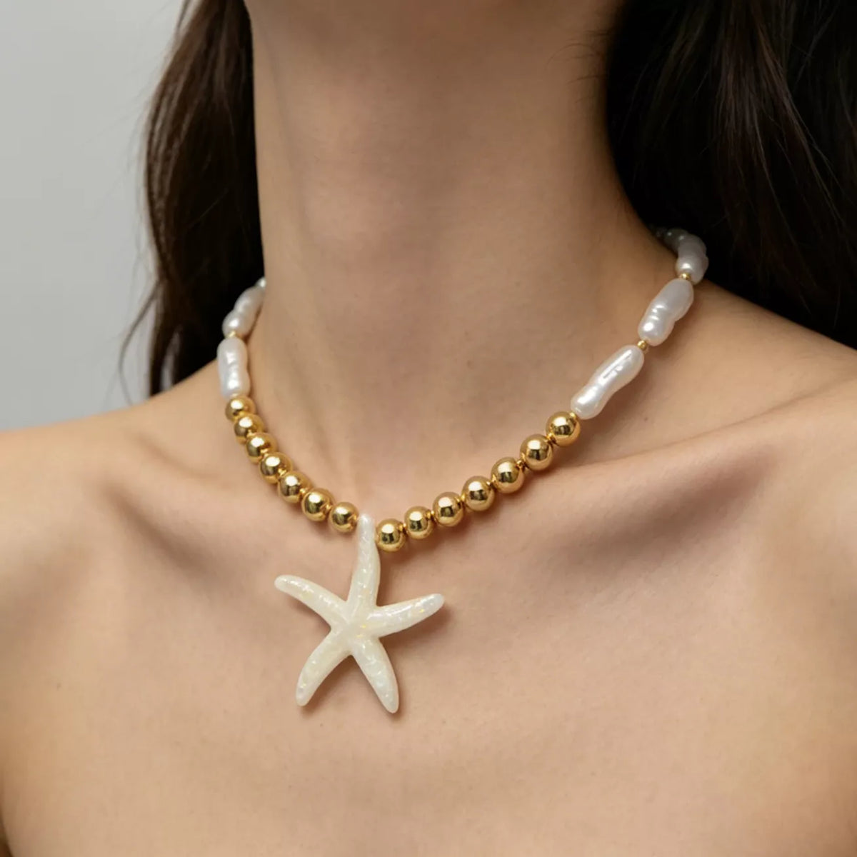 Starfish pendant necklace with gold-tone beads and white shell-like links