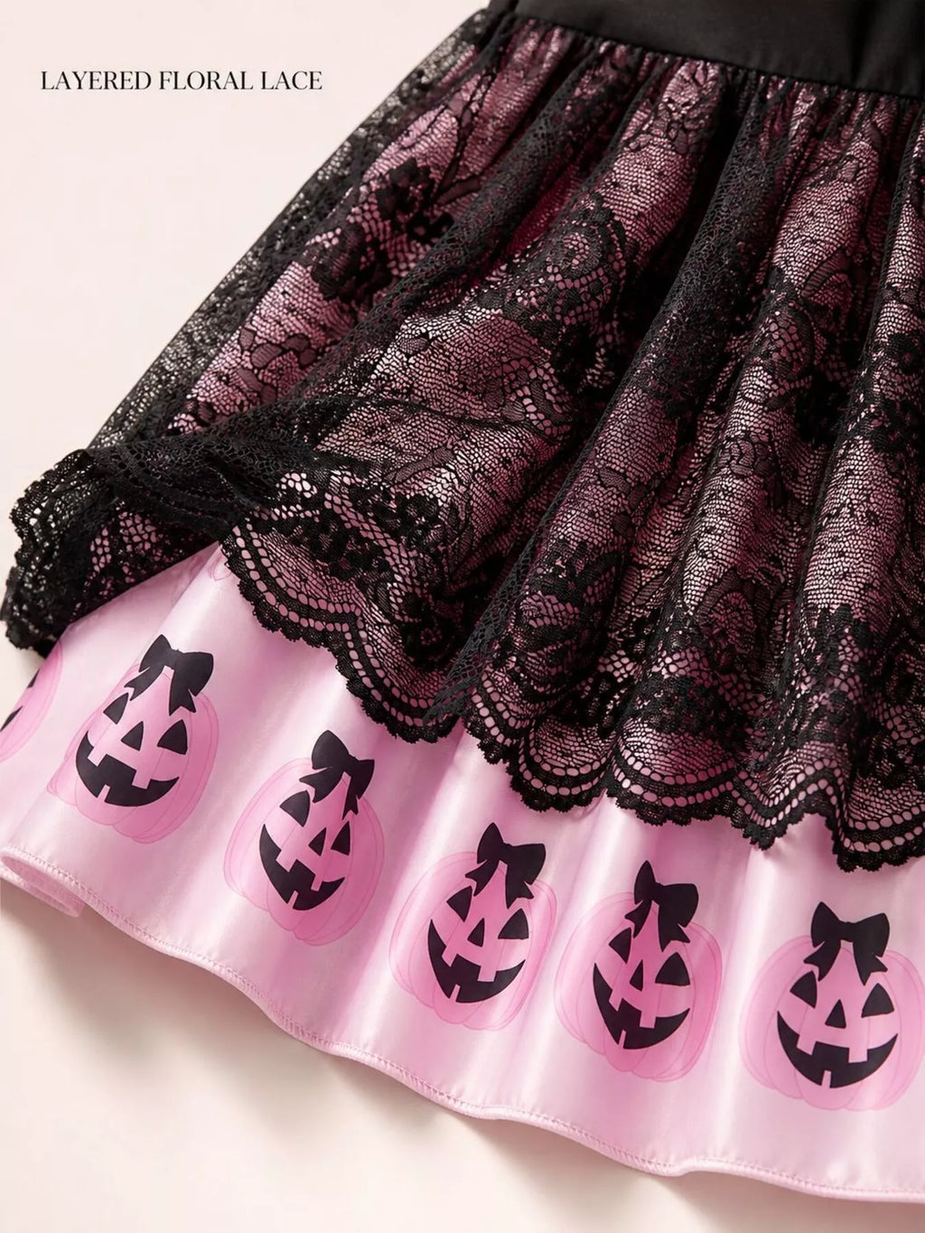 Close-up of the black floral lace overlay and pink jack-o'-lantern border.